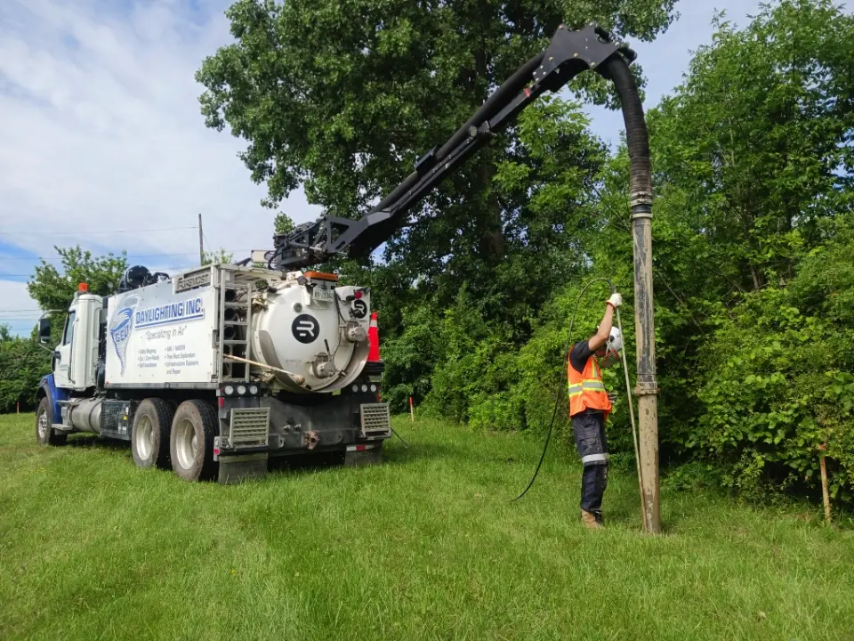 GEO daylighting truck with boom extended while a crew member works at the excavation point