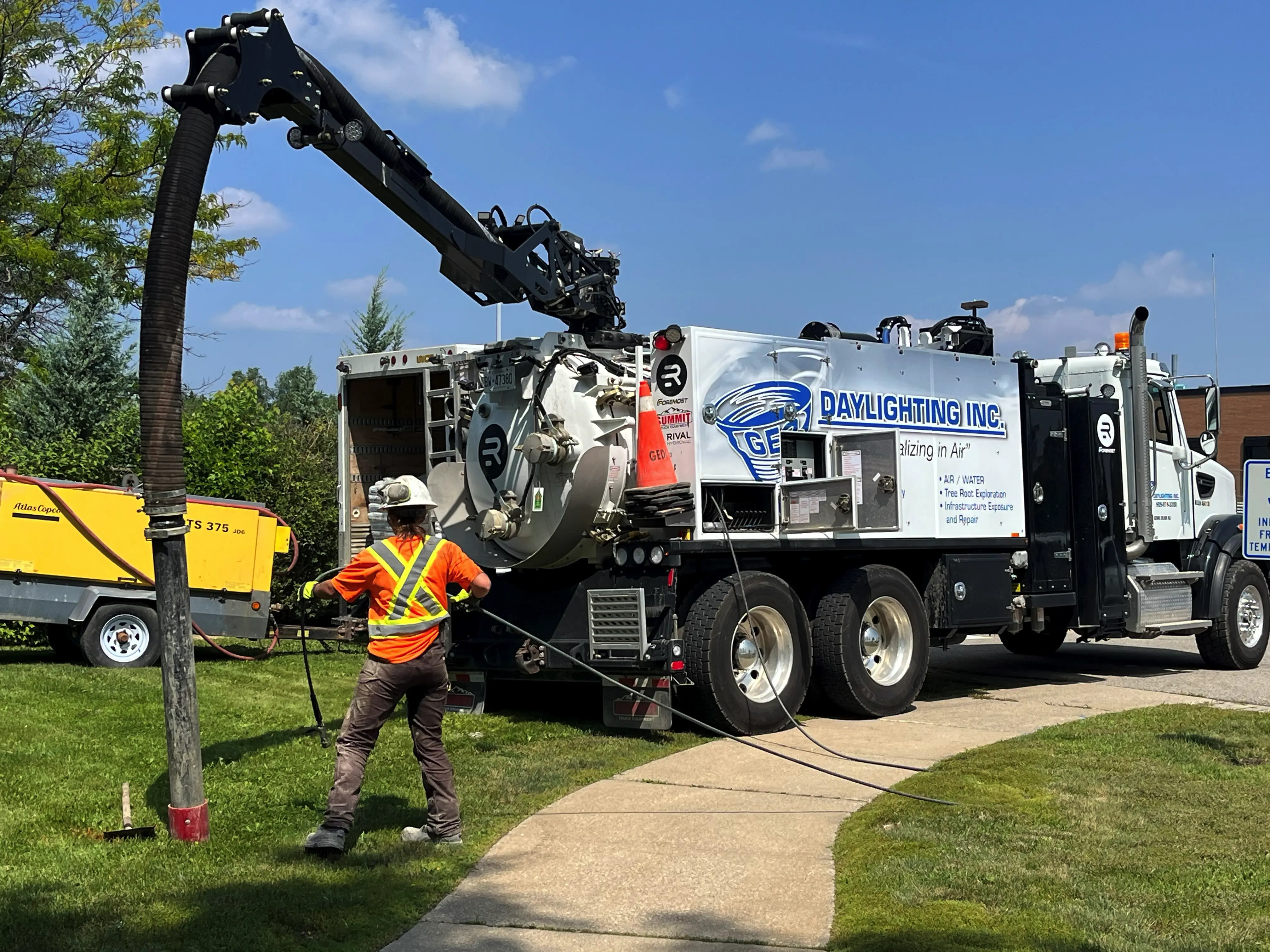 GEO hydrovac truck and hose supporting a water-excavation opening